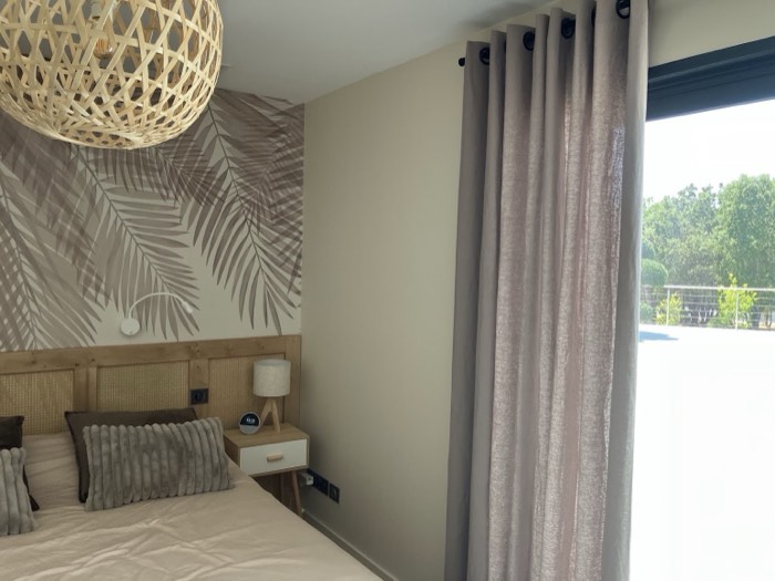 Chambre : panoramique feuilles de palmier et tête de lit en bois