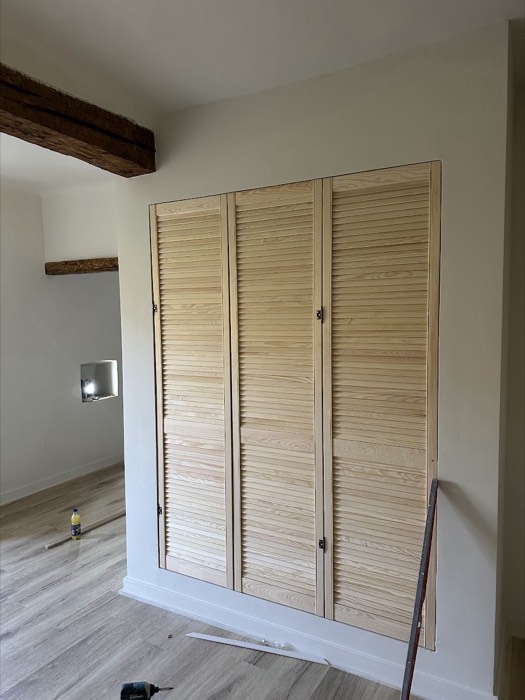 Placard sur mesure fermé par des portes persiennes en bois