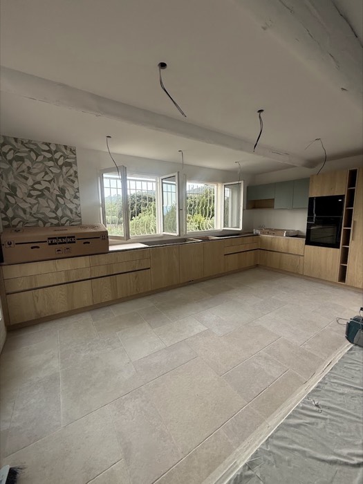 Carrelage grand format effet pierre dans une cuisine en cours de finition
