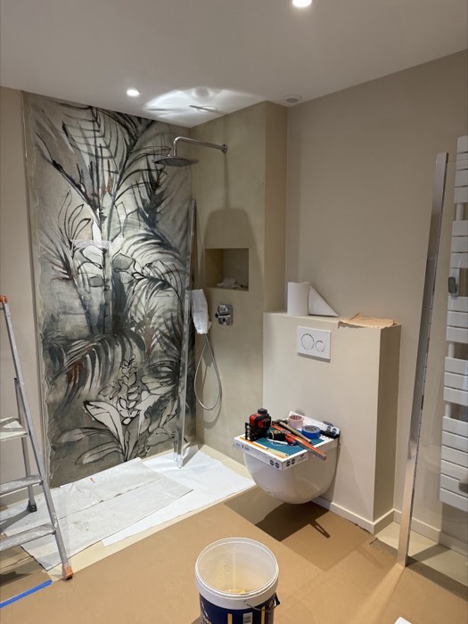 Panneau décoratif végétal grand format en cours de pose dans la douche