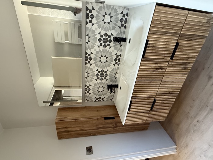 Crédence en carreaux à motifs étoilés et meuble vasque en bois cannelé