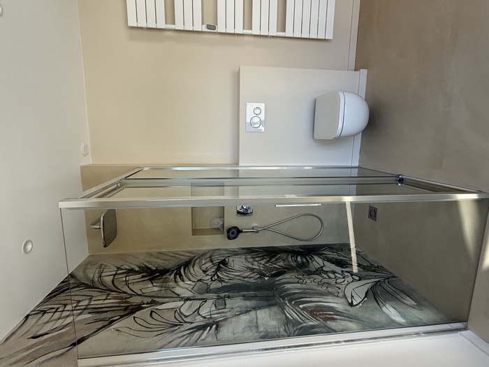 Douche vitrée sur fond de panneau décoratif végétal